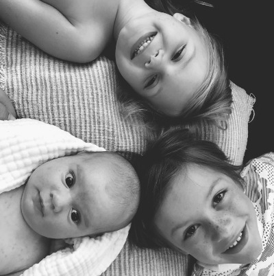 Waylon Tripp Parker laying on his back alongside his siblings, Rebel and Kit.